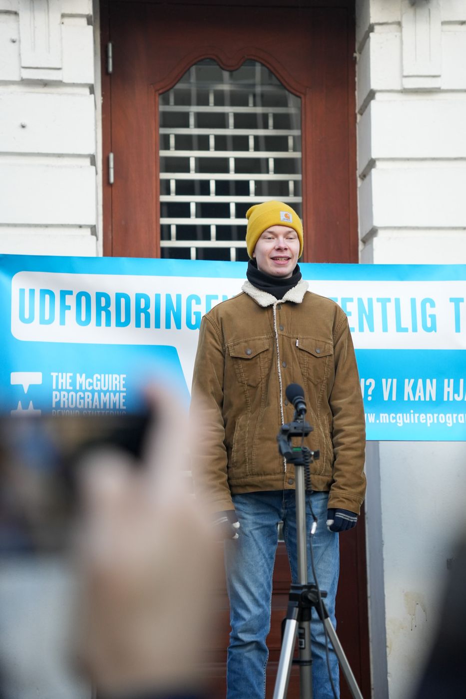 Kursist i gul hue holder tale ved mikrofonen